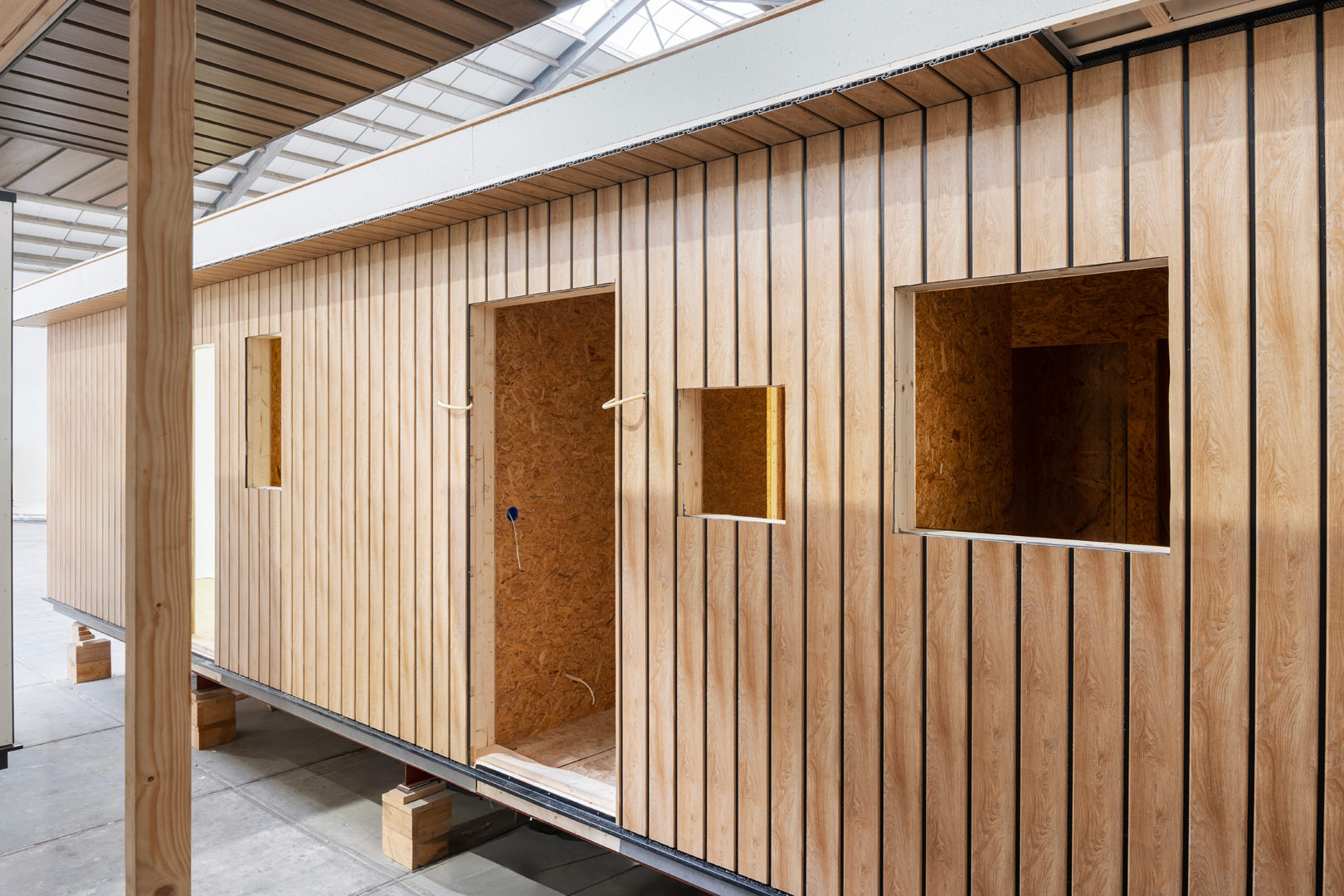 In een werkplaats die bruist van creativiteit, wordt een houten modulair gebouw gebouwd. De open delen onthullen het vakmanschap achter de gedeeltelijk afgewerkte buitenkant. Het vastleggen van dit proces door middel van videografie kan een uitstekende functie zijn voor uw website laten maken om online marketinginspanningen te verbeteren.