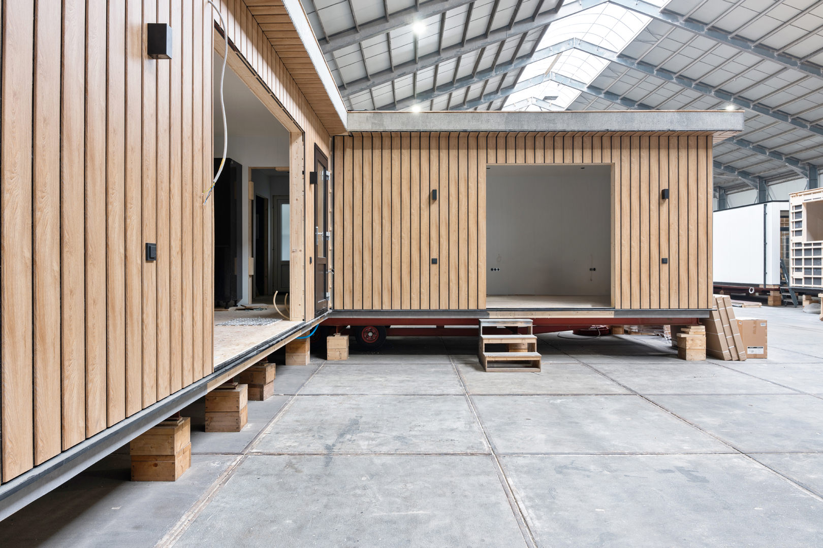 Fotografie van modulaire houten bouwconstructies legt de essentie van een pakhuisomgeving vast, waarbij gedeeltelijk open en onafgemaakte delen met artistieke flair worden getoond.